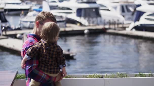 Vader houdt zoontje op handen op Zeedijk. Familie. Zomerdag. Kijken rivier — Stockvideo