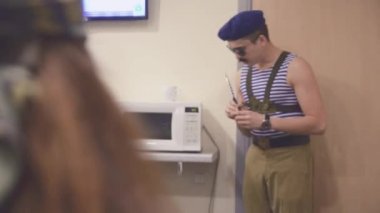 Deniz gömlek ve şapkası, güneş gözlüğü kalmak mikrodalga elinde bıçak ile bir adam. Konuşma. Sürrealizm