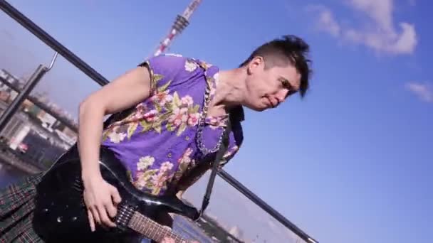 Man in scotland skirt, shirt play electric guitar on seafront in sunny day. Dance. Rock and roll — Stock Video