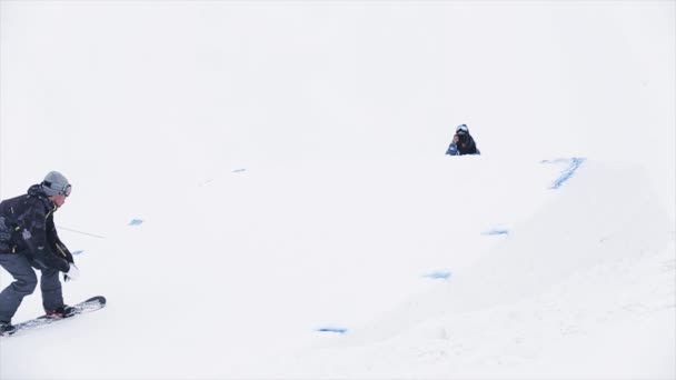 Snowboarder hoppe fra trampolin gøre ekstreme 360 flip i luften på snedækket bjerg. Konkurrence. Udfordring – Stock-video