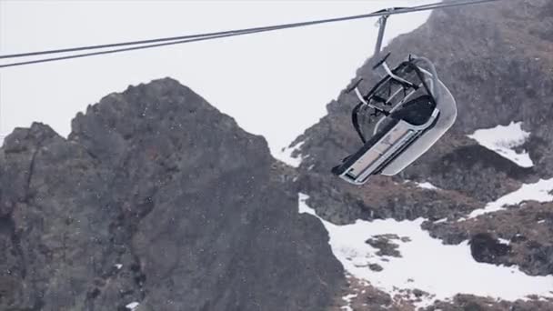 Pemandangan ski lift turun di pegunungan bersalju. Resor Ski. Salju turun. Snowboarding. Buka kabin — Stok Video