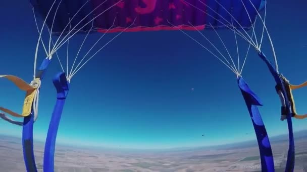 Professional skydiver parachuting in blue sky above sandy Arizona. Landscape — Stock Video