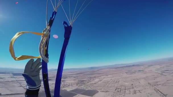 Penerjun payung profesional terbang dengan parasut di langit biru di atas pasir Arizona. Matahari — Stok Video