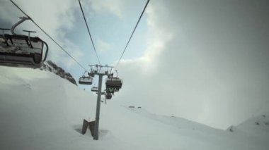 Dağlar, kayak asansörleri inşaat görünümünü. Kayak Merkezi. Snowboard. Açık kabin. Gri gökyüzü, bulutlar