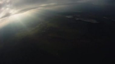 Skydiver yeşil alanlar yukarıda gökyüzünde paraşütle atlama. Aşırı spor. Bulutlu akşam.