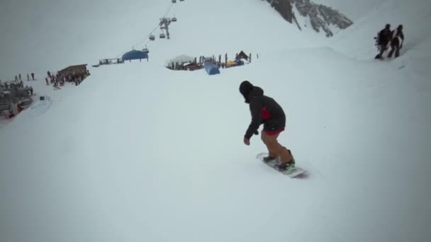 Snowboarder fahren auf Trampolin in der Luft am verschneiten Berg umdrehen. Extrem. Herausforderung. Menschen — Stockvideo