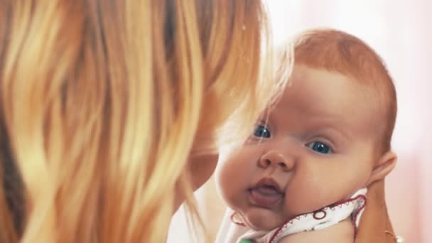 Maman tient sur les mains petit bébé mignon. Le bébé a les yeux bleus. Communication. Jouer — Video