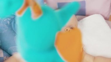 Küçük bebek yalan beşik renkli hareketli oyuncaklar yukarıda onu izliyor. Şirin.