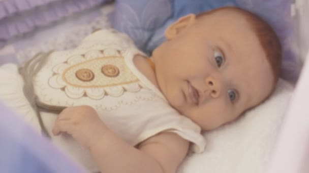 Baby liegt im Kinderbett und schaut sich um. Mutterschaft. Mutterschaft. Niedliches Kind. — Stockvideo