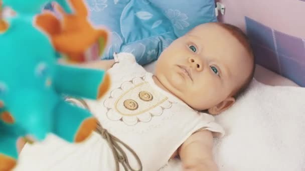 Μικρό μωρό ψέμα σε βρεφική κούνια. Πολύχρωμο κινούμενα παιχνίδια. Παιδική ηλικία. Η μητρότητα. Μητρότητας. — Αρχείο Βίντεο