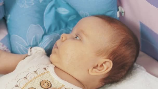 Petit bébé couché dans la crèche regarder des jouets colorés en mouvement au-dessus de lui. Charmant. Mouvements — Video