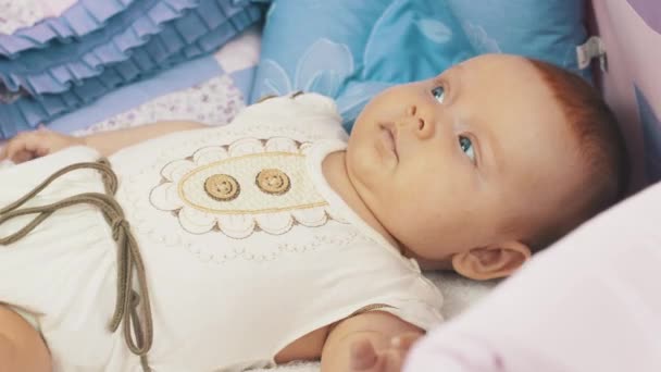 使用智能手机，坐在小娃娃躺在婴儿床上的母亲。做了母亲。儿童. — 图库视频影像