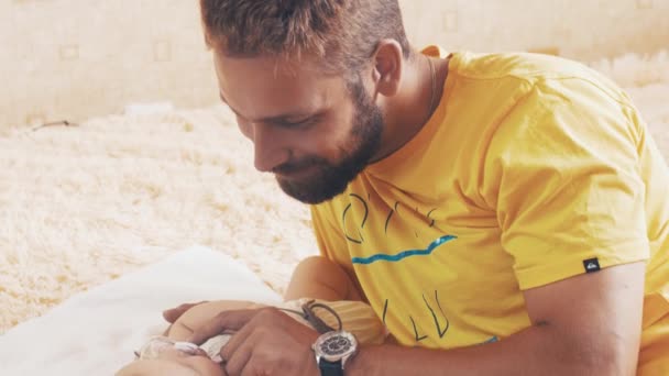 Bearded father lie with baby. Hold baby dummy. Parent. Family. Communication. — Stock Video