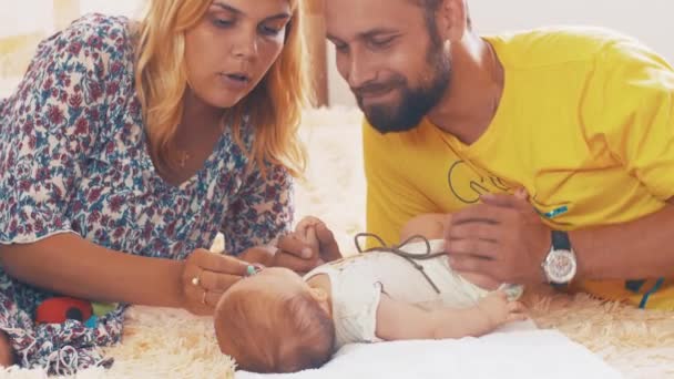 Happy parents communicate with little baby. Family. Father and mother kiss — Stock Video