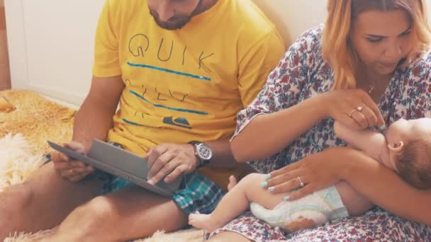 Les parents rentrent avec bébé. La famille. Père joue en tablette. Mère AVC enfant — Video