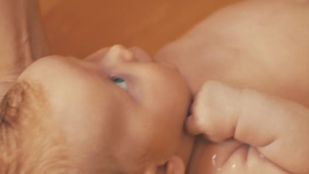 Mãe banho pequeno bebê bonito com olhos azuis. Banho amarelo. Maternidade. Cuidados — Vídeo de Stock