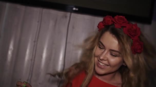 Glücklich DJ-Mädchen in rotem Kleid mit Felge auf dem Kopf Sprung am Plattenteller in Nachtclub. — Stockvideo