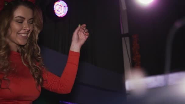 Dj girl in abito rosso con cerchio sul capo danza al giradischi in discoteca. Alzare la mano . — Video Stock