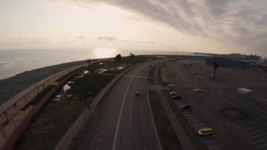 Quadrocopter ateş Road'da Sahili ve sunset beach. İnsanlar. Manzara. Arabalar
