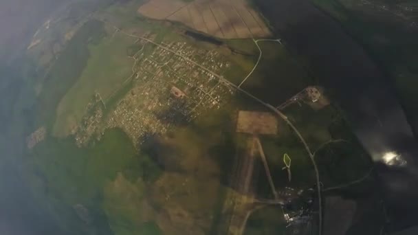 Yeşil alanlar yukarıda gökyüzü profesyonel skydiver sinek. Paraşüt açılır. Güneşli gün — Stok video