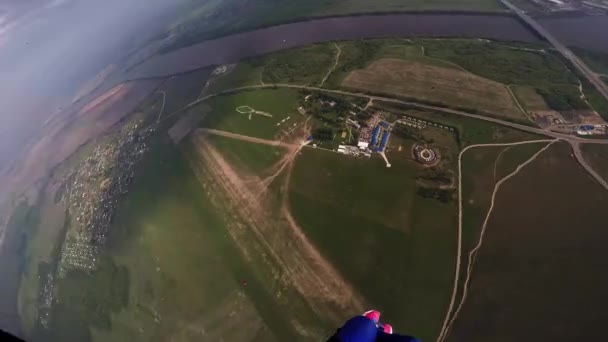 专业跳伞飞在天空上面绿色的田野，河。阳光灿烂的日子。景观 — 图库视频影像