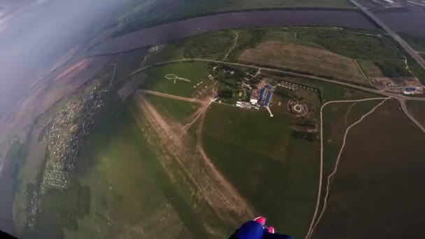 O skydiver profissional voa no céu acima dos campos verdes, rio. Dia ensolarado. Paisagem — Vídeo de Stock