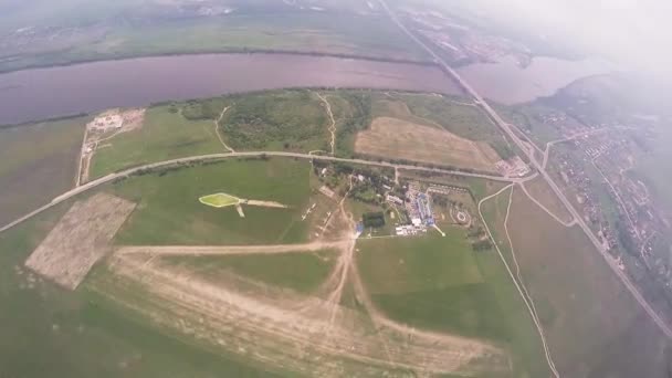 Professionella fallskärmshoppare flyger i himlen ovanför gröna fält, floden. Sun. landsbygden. — Stockvideo