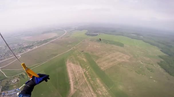 Professional skydiver fly in sky above green fields. Sun. Landscape. Scenery. — Stock Video