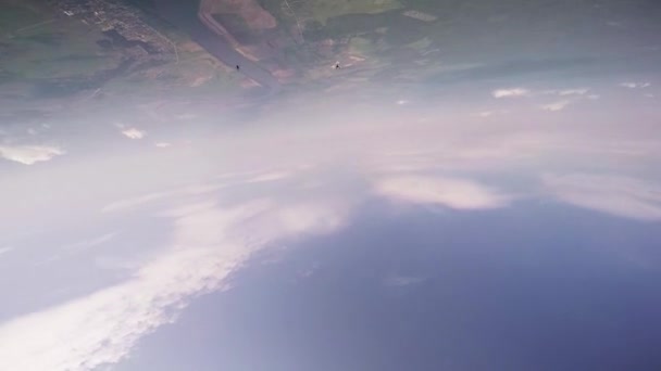 Професійний лижник літає в блакитному хмарному небі над зеленими полями. Літо. Політ . — стокове відео