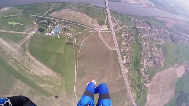 Professionele skydiver parachutespringen boven groen flatland. Zomer. Landschap. Rivier — Stockvideo