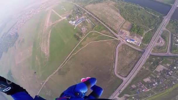 Professioneller Fallschirmspringer beim Fallschirmspringen über dem grünen Flachland. Höhe. Landschaft. Fluss — Stockvideo