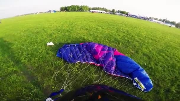 Fallschirmspringer schnüren Fallschirm auf der grünen Wiese. Sommer. Landschaft. Sport — Stockvideo