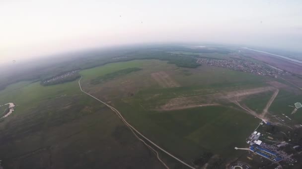 Επαγγελματική skydiver πτώση με αλεξίπτωτο πάνω από πράσινα λιβάδια. Το καλοκαίρι. Τοπίο. Φύση — Αρχείο Βίντεο