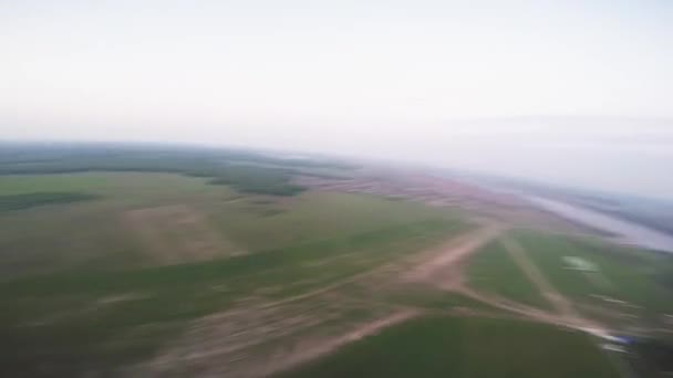 Paracaidista profesional paracaidismo por encima de la llanura verde. Verano. Escenario. Buenas noches. — Vídeo de stock