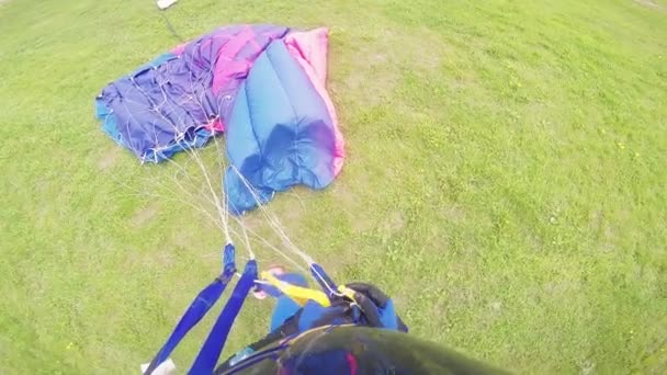 Profi-Fallschirmspringer schnüren Fallschirm nach der Landung auf der grünen Wiese. Natur. Sport. — Stockvideo
