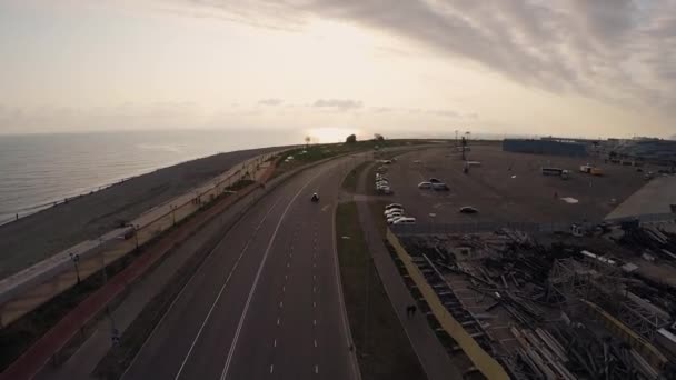 Quadrocopter schießen Straße an Küste und Strand bei Sonnenuntergang. Menschen gehen. Landschaft — Stockvideo