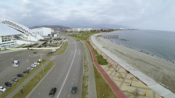 Quadrocopter schiet weg aan kust in grijze dag. Stadion in aanbouw. — Stockvideo