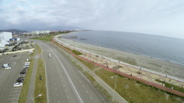 Quadrocopter menembak jalan di pantai dan pantai pada hari abu-abu. Orang-orang bersepeda . — Stok Video