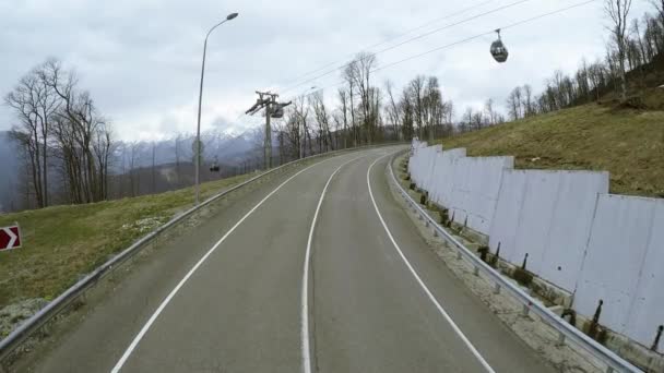 Quadrocopter natáčení silnice v horách. Lyžařské vleky. Zasněžené vrcholy. — Stock video