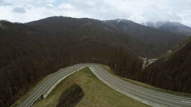 Quadrocopter vliegt boven serpentine weg in de bergen. Skiliften. Landschap. — Stockvideo