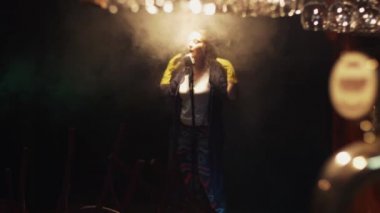 Scrubwoman eldiven şarkı spot altında vintage mikrofon sahnede. Duman.