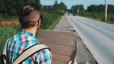 Genç çocuk Road Karton tabak ile yaz güneşli bir günde otostop. Seyahat.