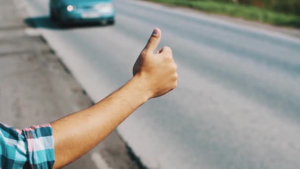 Boy hitchhiking at road in summer sunny day. Tourist. Hold thumb up. Traveling — Stock Video