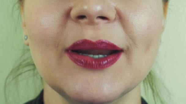 Femme avec pommade rouge montrer les dents, sourire devant la caméra. La bouche. Le visage. Maquillage — Video