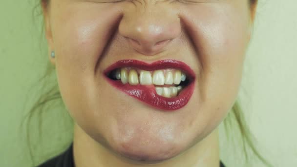 赤いポマードのかみ傷を持つ女性は唇の前カメラです。口。笑顔。舌. — ストック動画