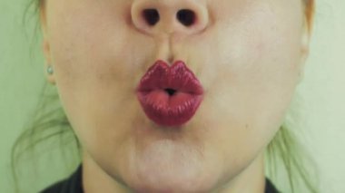 Kadın kırmızı pomad gülümseme ile kamera kelimeleri telaffuz. Ağız. Diş. Hava öpücük