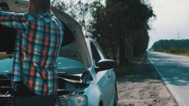 Kızgın çocuk kırık araba başlık altında yola bak. Yardım bekliyor. Sorun.