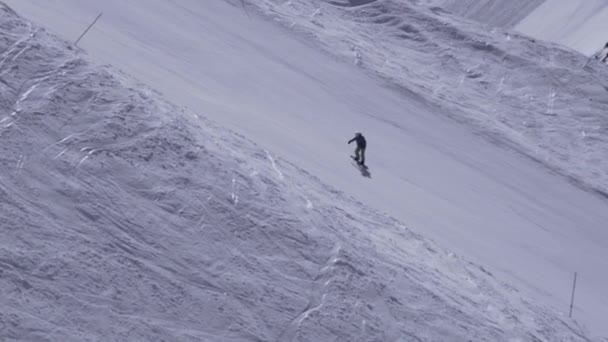 スキー リゾート。スノーボーダーに乗って斜面。速度。スプレーしてください。白い山。晴れた日 — ストック動画