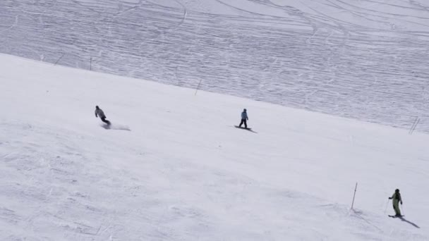 Χιονοδρομικό κέντρο. Snowboarders βόλτα στην πλαγιά. Λευκά Όρη. Ηλιόλουστη μέρα. Σκιέρ. Αθλητισμός — Αρχείο Βίντεο