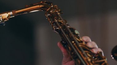 Saksafoncu altın saksafonla oynuyor. Canlı performans. Caz sanatçısı. Müzisyen